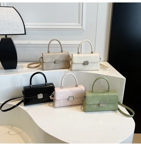 Minimalist square handbags in five colors displayed on white stairs with a modern lamp