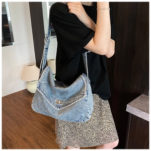 Dettaglio della borsa tote in denim azzurro con chiusura a scatto in metallo argento