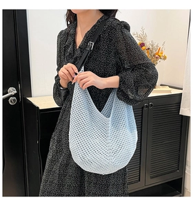 Detail of light blue woven bucket bag with adjustable black leather shoulder strap and mesh