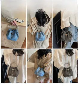 Detail showing versatile styling of a mini bucket bag with pearl tassels and butterfly buckle