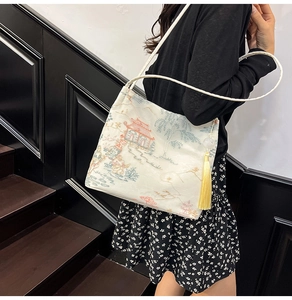 Detail of traditional Chinese embroidery on a white bucket bag with elegant long tassels