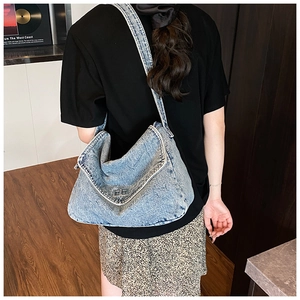 Vista posteriore dettagliata di una borsa a tracolla in denim blu con chiusura in metallo