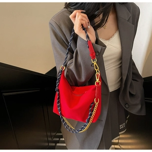 Close-up of red nylon dumpling bag with woven rope and golden metal chain detail