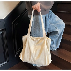 Detail of cream canvas tote bag showing textured fabric and JUMAFFU embossed lettering