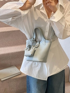 Elegant light blue lychee pattern bucket bag with a mini charm and detachable strap