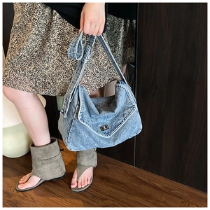 Primo piano dettagliato della borsa hobo in denim blu con chiusura a scatto in metallo