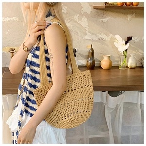 Hollow out woven straw tote bag for women shown in a cozy indoor lifestyle scene
