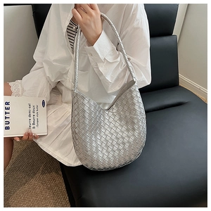 Vue détaillée de la texture en cuir tressé argenté d'un sac à bandoulière de style Hobo