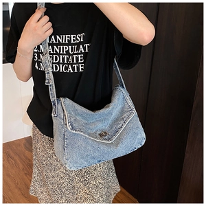 Dettaglio della borsa a tracolla in denim blu vintage con fibbia a scatto in metallo