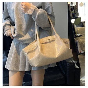 Detail van minimalistische beige shopper met krokodillenpatroon en gouden gesp detail