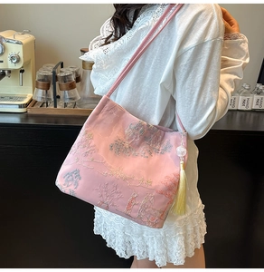 Detail of pink silk bucket bag with traditional Chinese embroidery and tassel charm