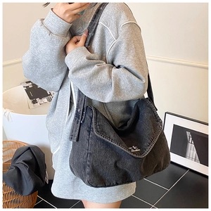 Dettaglio macro della borsa tote in denim nero lavato con chiusura a fibbia in metallo