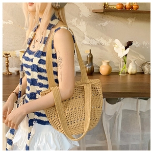 Detail of hollow woven texture and wide handles on the khaki crochet beach tote bag