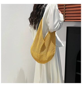 Detail shot of bright yellow crochet knit bag with black leather strap and adjustable buckle
