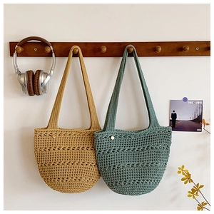 Detail of hand-woven hollow crochet tote bags in mustard yellow and sea green colors
