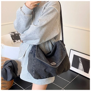 Dettaglio borsa a tracolla in denim nero lavato con cuciture a contrasto e fibbia metallica