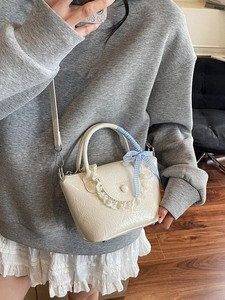 Sac seau plissé crème avec bordure en dentelle et nœud à carreaux sur modèle
