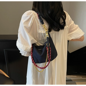 Detail of navy nylon hobo bag with red woven rope and gold chain multi-strap system