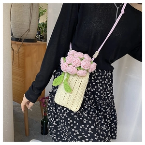 Detail of handmade crochet knit bag with pink floral rose and light wooden beads
