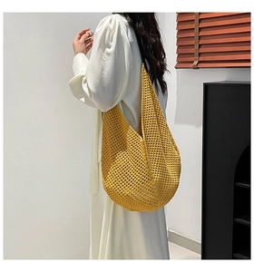 Detail of yellow hollow crochet mesh shoulder bag with soft textured woven pattern
