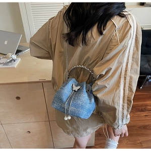 Blue denim texture bucket bag with glitter finish and metallic butterfly detail