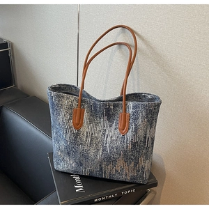 Detailed close-up of sequined large tote bag with brown leather straps and wave texture