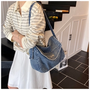 Dettaglio della borsa a spalla in denim vintage con chiusura a scatto in argento
