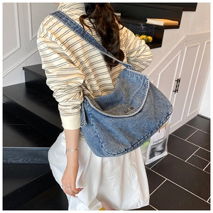 Vista dettagliata della borsa tote in denim lavato con chiusura a rotazione in metallo e tracolla