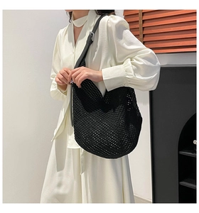 Detail of black woven knit tote bag with mesh design and adjustable leather shoulder strap