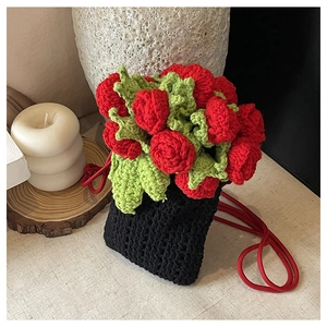 Gros plan détaillé d'un sac seau au crochet noir avec des motifs floraux rouges