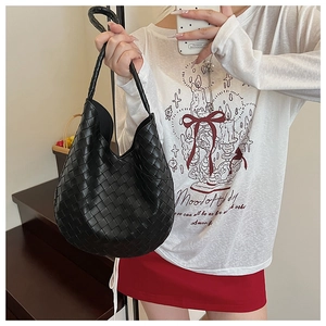 Gros plan sur le sac hobo en cuir tressé noir montrant les détails de la texture entrelacée