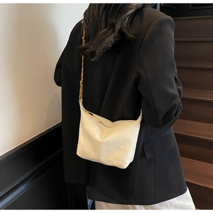 Detailed view of beige nylon crossbody bag with adjustable rope strap on a model
