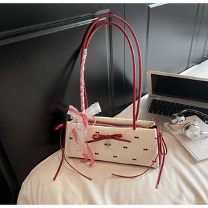 Dettaglio del fiocco rosso, pizzo e ciondolo a cuore sulla borsa a pois stile vintage