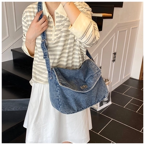 Borsa a tracolla in denim blu con chiusura a scatto argento indossata da modella