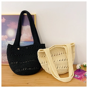 Detailed close-up showing black and beige hollow-out woven tote bags on a wooden surface
