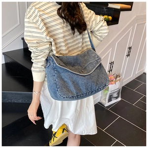Dettaglio ravvicinato della borsa in denim blu lavato con chiusura a scatto in metallo
