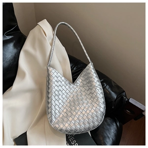 Détail de la texture tissée argentée d'un sac porté épaule chic en forme de croissant