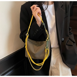 Detail of olive nylon hobo bag with yellow cord strap and gold chain on model