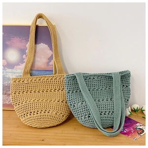 Detailed macro view of beige and blue crochet knit hollow tote bags on wooden surface