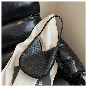 Détail d'un sac cabas en cuir tressé noir avec texture Intrecciato et finition souple