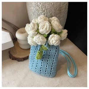Gros plan détaillé du sac seau bleu fait main avec des accents de fleurs blanches