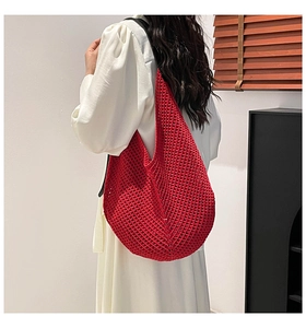 Detail of red crochet knit hobo bag showing intricate mesh texture and black wide strap