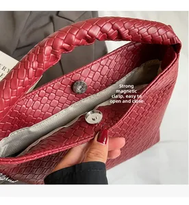 Detail of red woven bucket bag showing strong magnetic closure and textured faux leather