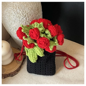 Close-up of handmade black knit phone bag with red 3D rose flower and drawstring strap