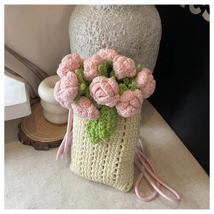 Détail d'un sac seau au crochet fait main avec des roses 3D roses et feuilles vertes