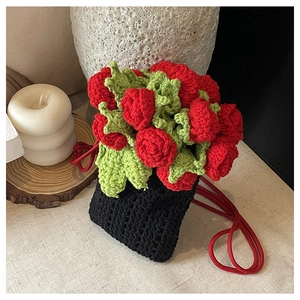 Close-up of handmade crochet bucket bag featuring 3D red roses and green leaves detail