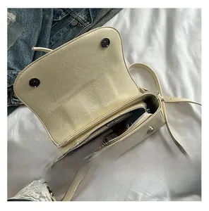 Internal view of beige wrinkled leather crossbody bag showing inner pocket and capacity