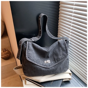 Dettaglio borsa a tracolla in denim grigio lavato con chiusura a rotazione in argento