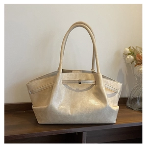 Detail van beige shopper tas met elegante krokodillenstructuur en metalen sluiting