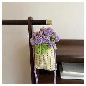 Detailed macro view of handmade crochet rose flowers on a beige knit bucket bag